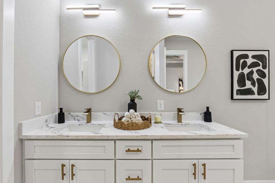 Double vanity featuring elegant gold-toned fixtures and ample counter space for daily routines.