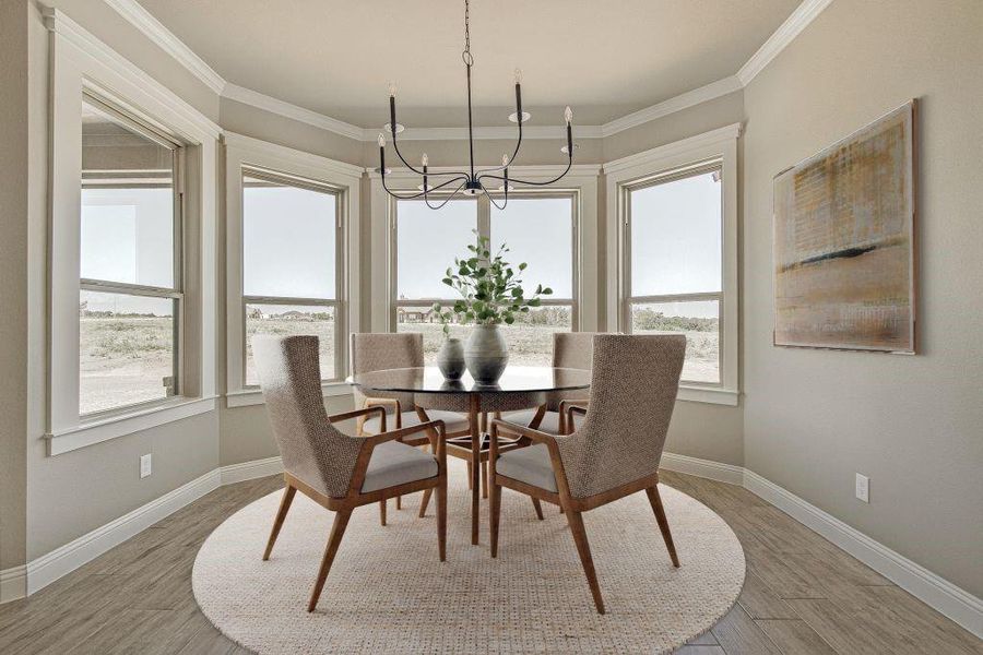 Dining space featuring crown molding, plenty of natural light, an inviting chandelier, and light hardwood / wood-style flooring