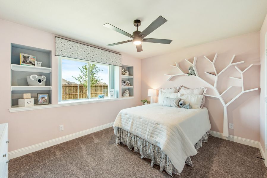Children's bedroom with pink walls, tree-shaped wall shelves, built-in shelving, and ceiling fan