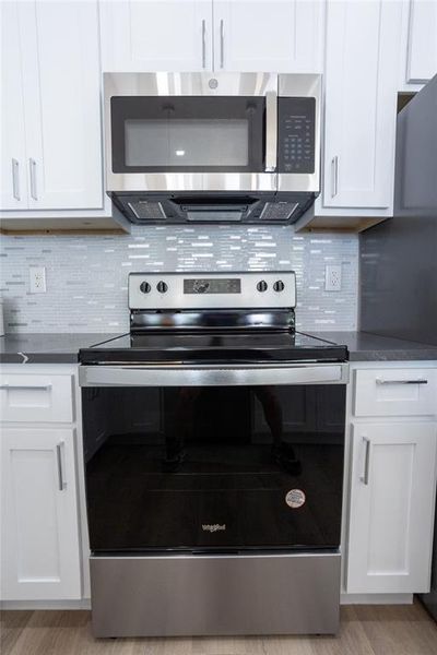 Kitchen featuring light wood-type flooring, white cabinetry, and stainless steel appliances