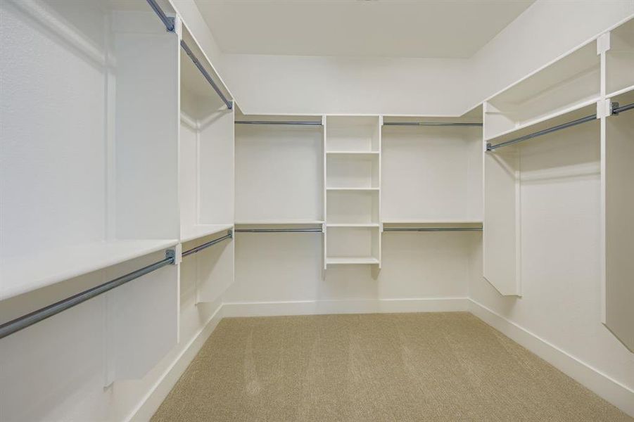 Walk in closet featuring light colored carpet Walk in closet featuring light colored carpet
