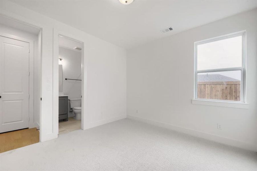 Carpeted interior room with white walls, a single window, and a recessed ceiling light fixture