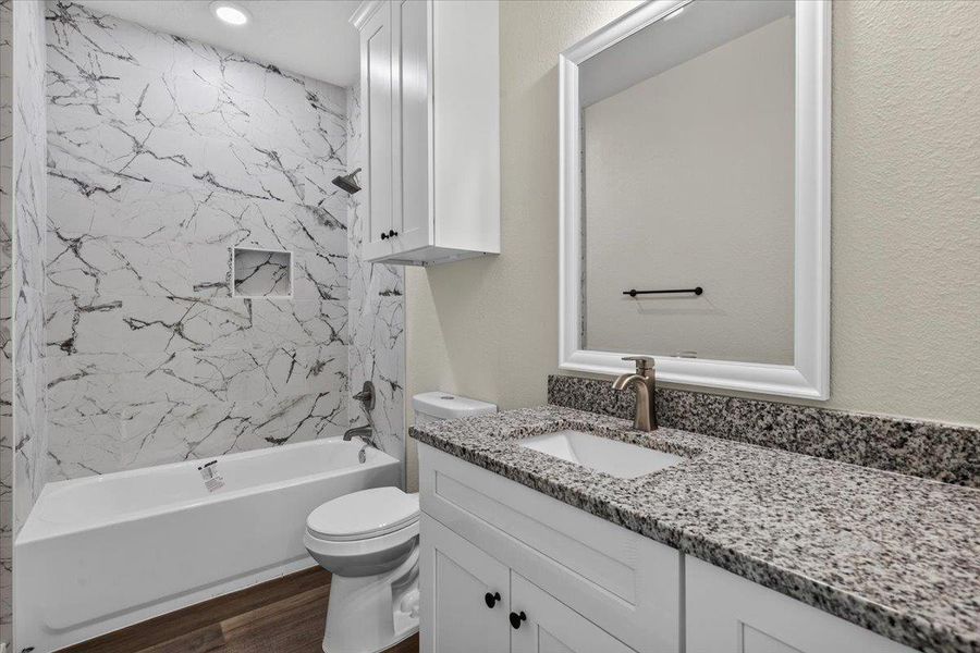 Polished granite countertops complement modern tiled tub surrounds in this updated bath. Polished granite countertops complement modern tiled tub surrounds in this updated bath.