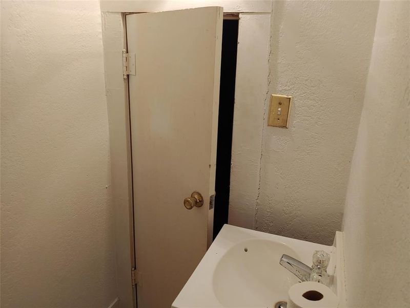 Half bath with pedestal sink featuring chrome faucet with clear handles and an adjacent light switch Half bath with pedestal sink featuring chrome faucet with clear handles and an adjacent light switch