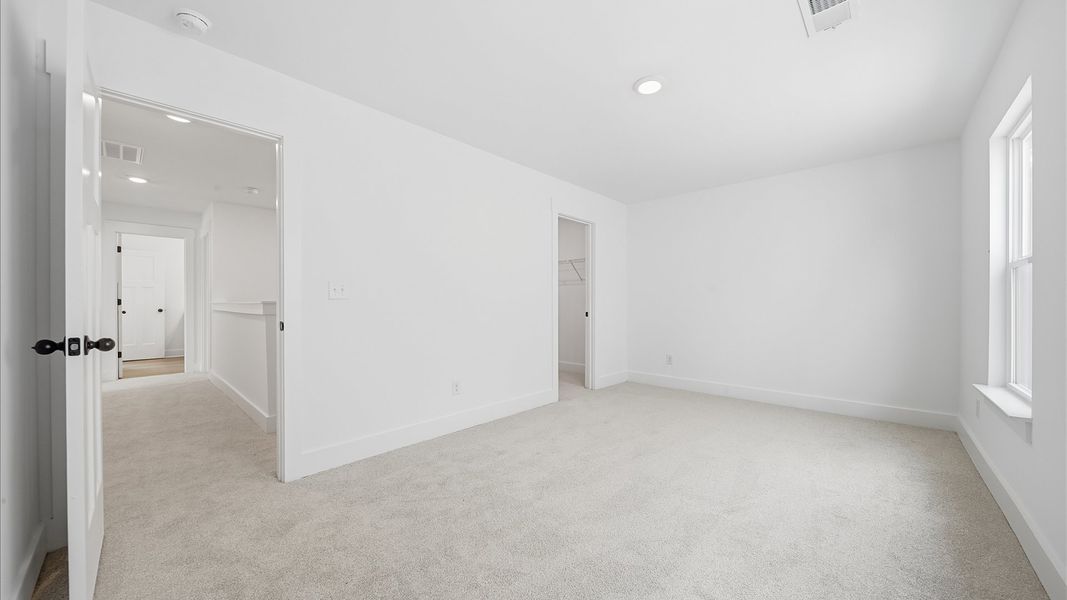 Elegant bedroom retreat featuring soft carpet and oversized windows that create a bright, welcoming space Elegant bedroom retreat featuring soft carpet and oversized windows that create a bright, welcoming space