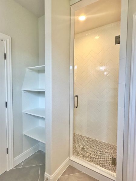 Bathroom featuring tile patterned flooring and a stall shower Bathroom featuring tile patterned flooring and a stall shower