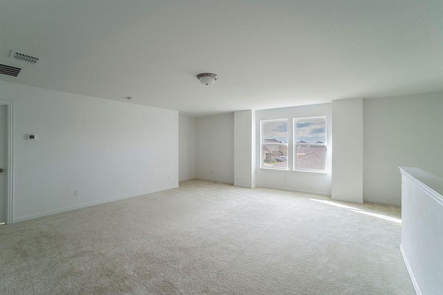 Carpeted empty room featuring baseboards Carpeted empty room featuring baseboards