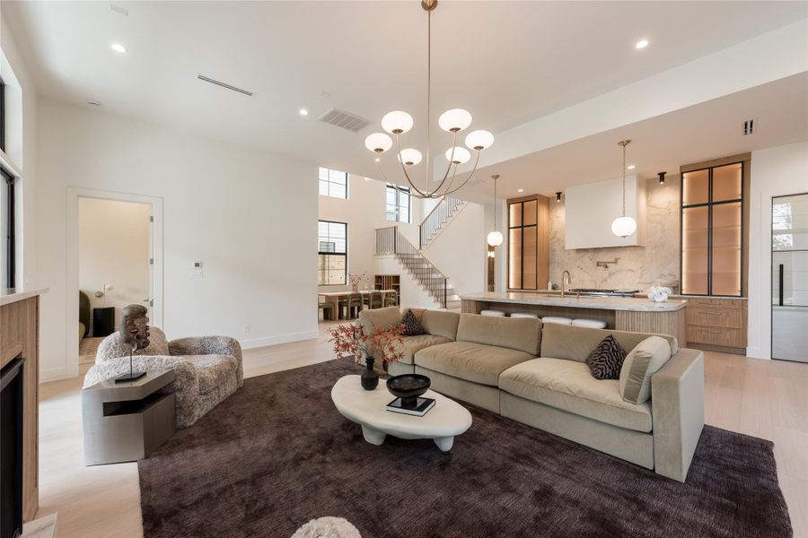 The great room brings the home’s architecture into one frame, with 12 foot ceilings, a statement fireplace and an open connection to the kitchen and dramatic two story dining room beyond. The great room brings the home’s architecture into one frame, with 12 foot ceilings, a statement fireplace and an open connection to the kitchen and dramatic two story dining room beyond.