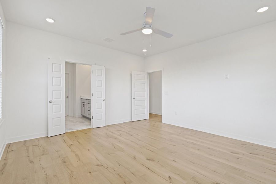 Unfurnished bedroom with recessed lighting, a ceiling fan, light wood-type flooring, and ensuite bath
