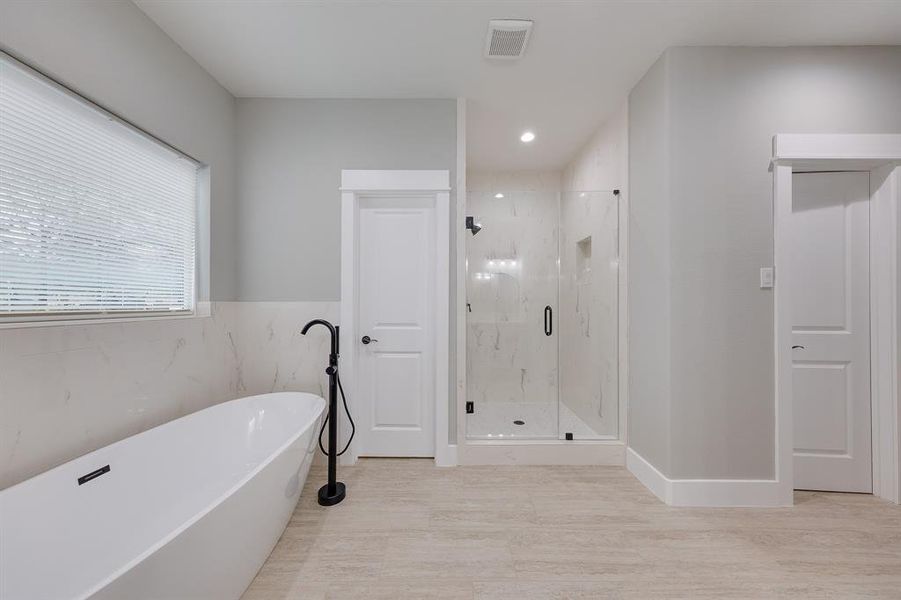 Primary bath with a separate walk-in shower, offering a spacious and refreshing experience for ultimate comfort.