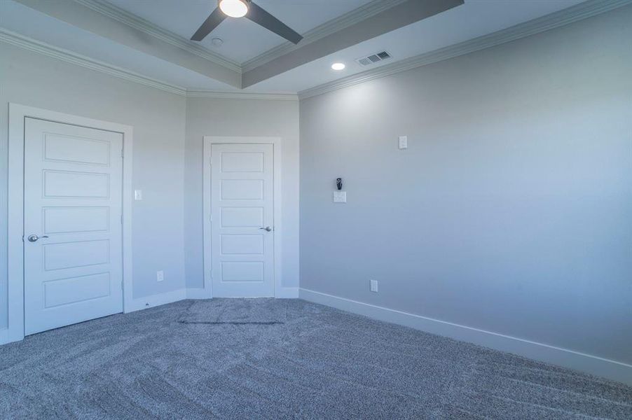 Spare room with carpet flooring, crown molding, a ceiling fan, a raised ceiling, and recessed lighting
