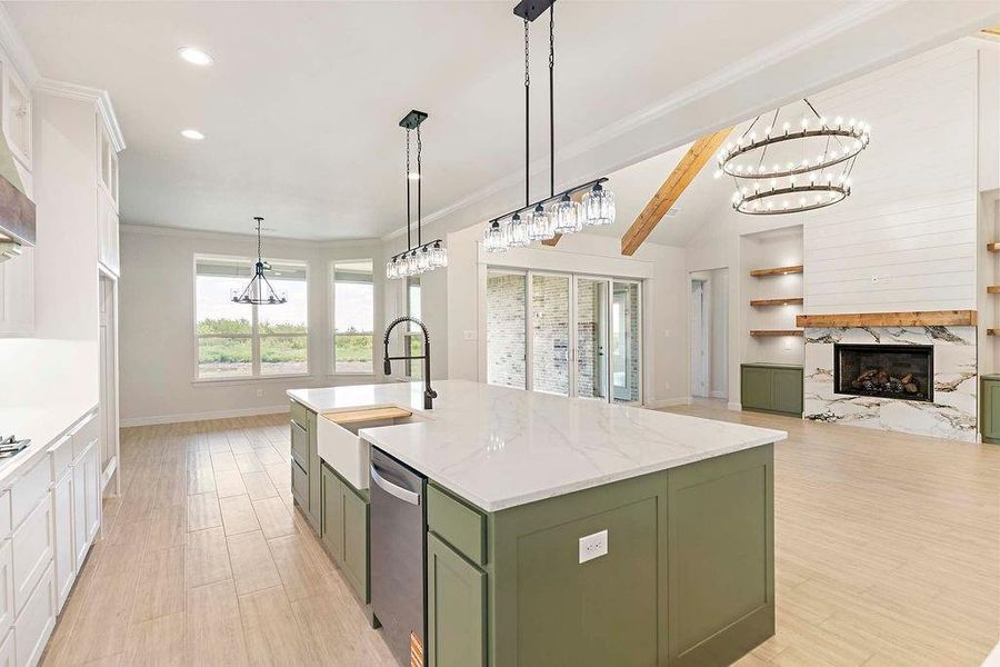 Kitchen featuring green cabinets, white cabinetry, a chandelier, a center island with sink, and decorative light fixtures