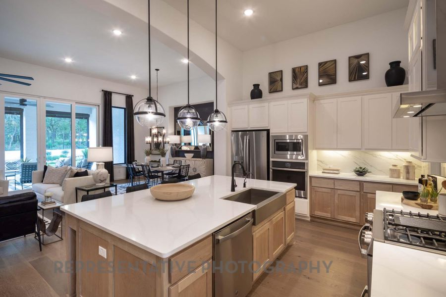 Kitchen with stainless steel appliances, a sink, tasteful backsplash, a kitchen island with sink, and dark wood finished floors Kitchen with stainless steel appliances, a sink, tasteful backsplash, a kitchen island with sink, and dark wood finished floors