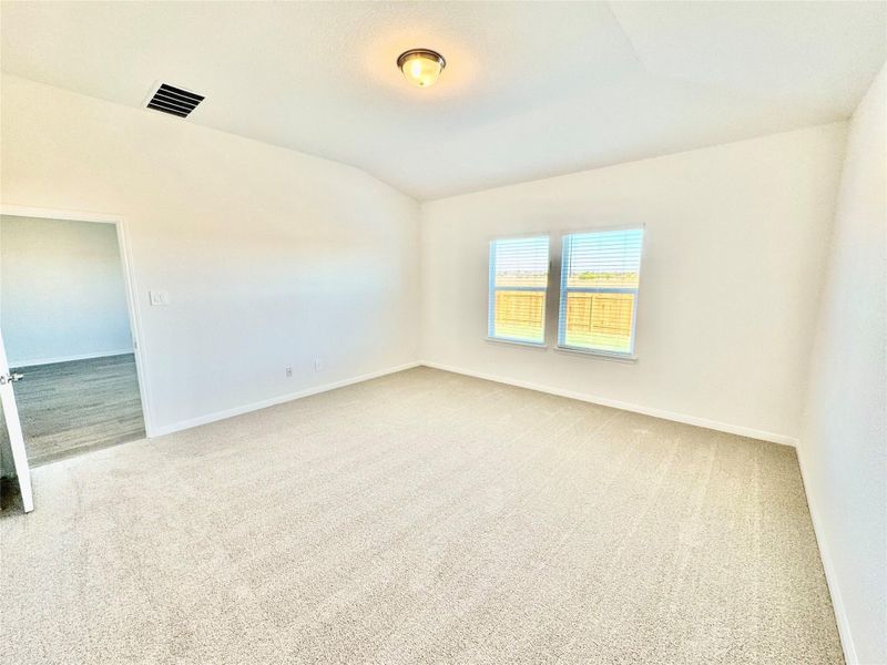 Unfurnished room with light colored carpet and vaulted ceiling Unfurnished room with light colored carpet and vaulted ceiling