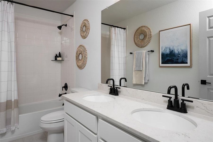 The secondary bath features tile flooring, white cabinetry and light countertops and a shower/tub combo. Perfect for accommodating any visiting family and friends.