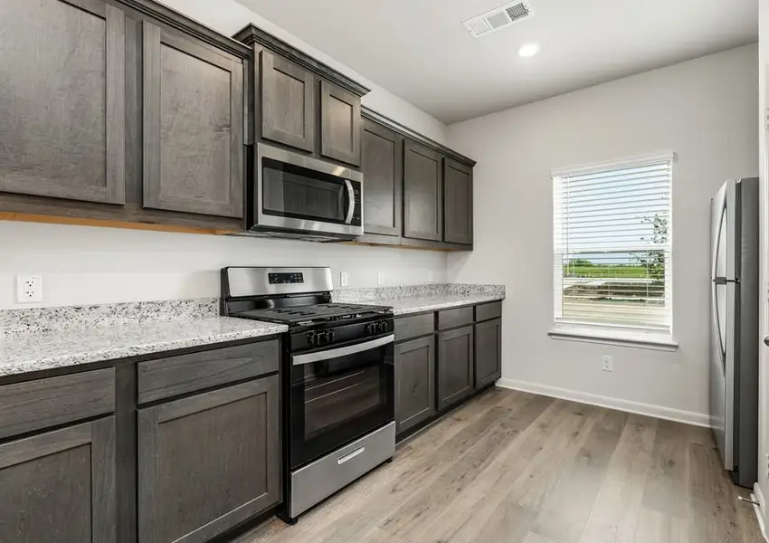 The kitchen has gorgeous brown cabinetry.