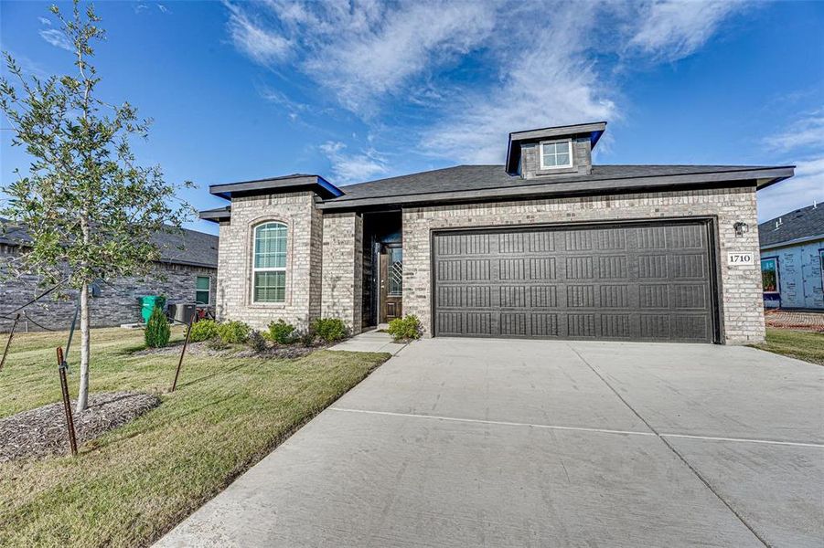 View of front of house featuring a front yard and a garage