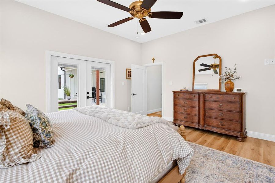 Bedroom featuring french doors, light wood finished floors, ceiling fan, and access to exterior Bedroom featuring french doors, light wood finished floors, ceiling fan, and access to exterior