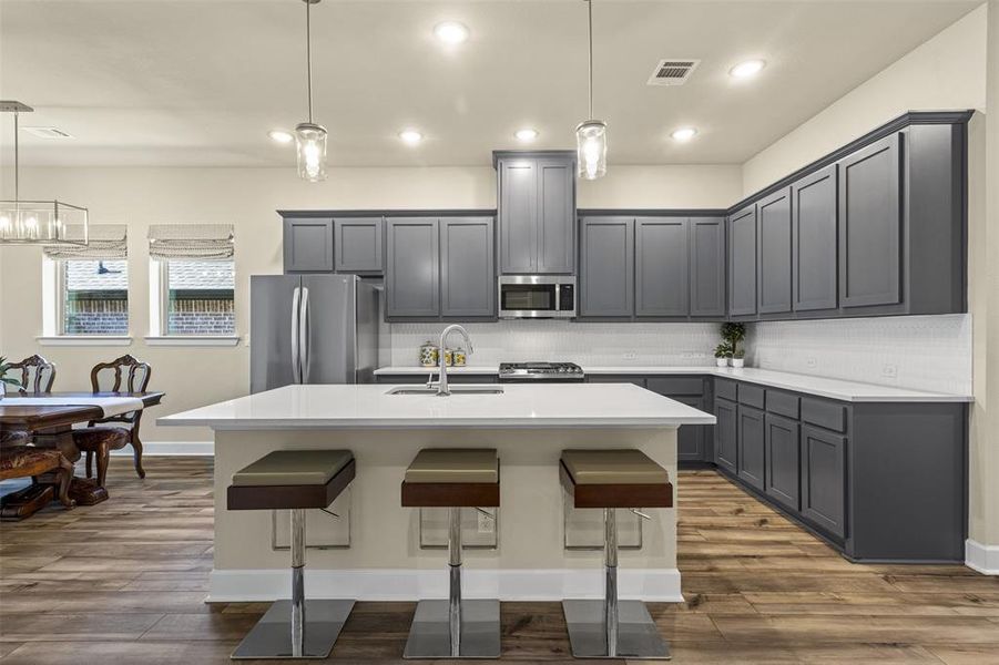 Kitchen featuring tasteful backsplash, a kitchen breakfast bar, stainless steel appliances