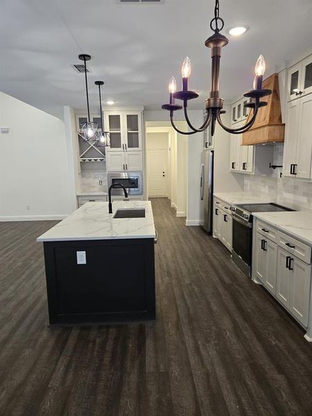 Kitchen featuring white cabinetry and dark hardwood / wood-style floors