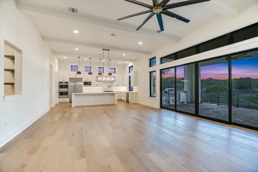 Living room with beam ceiling, ceiling fan, light wood-style flooring, and recessed lighting