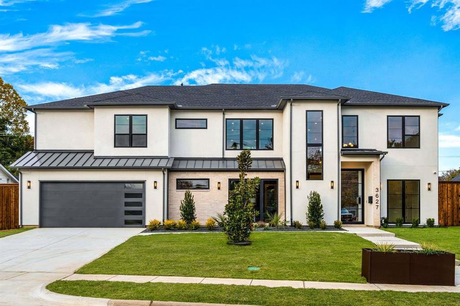 View of front of property with an attached garage, driveway, stucco siding, and a standing seam roof View of front of property with an attached garage, driveway, stucco siding, and a standing seam roof