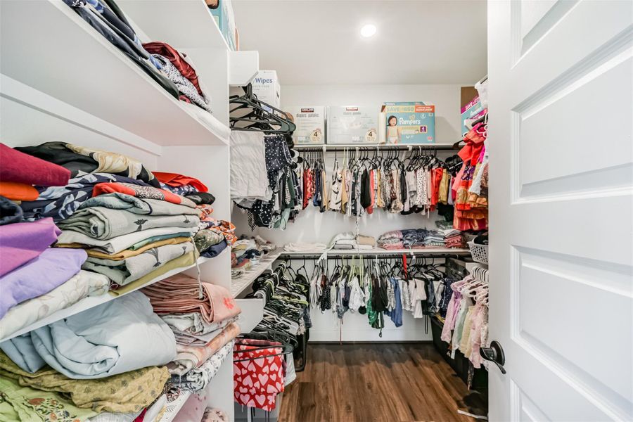 Primary closets featuring sturdy shelves and wooden dowels, perfectly designed for organized clothing storage and hanging. Primary closets featuring sturdy shelves and wooden dowels, perfectly designed for organized clothing storage and hanging.
