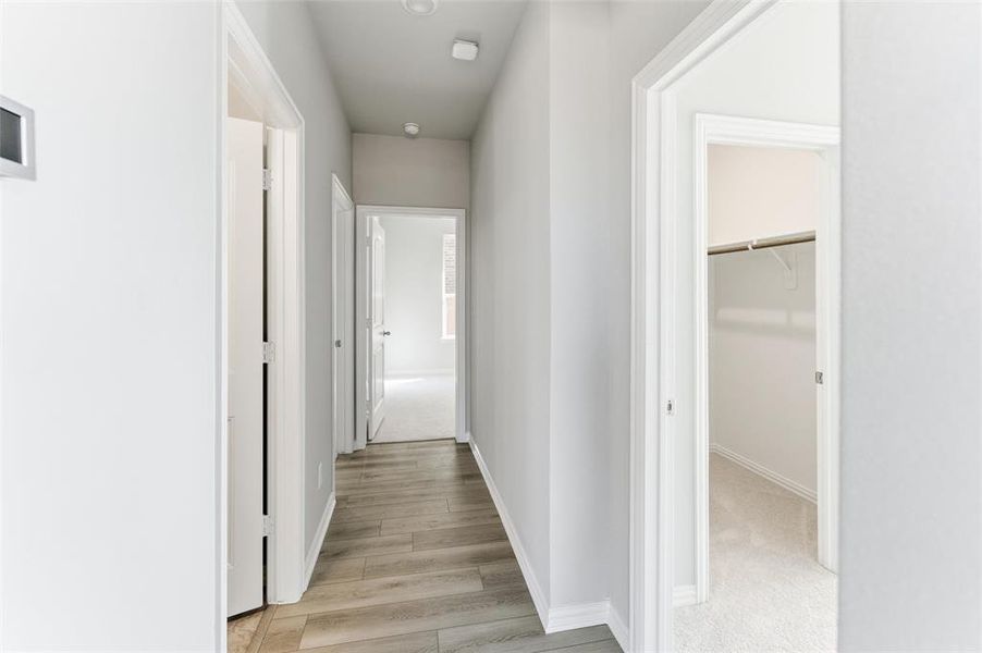 Hall featuring baseboards and light wood-style flooring
