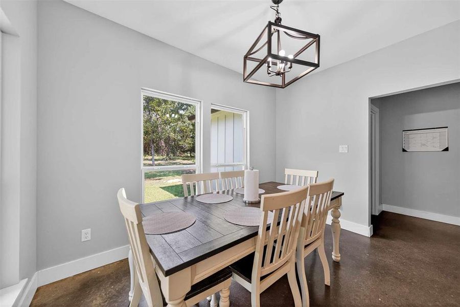 Dining area featuring finished concrete floors and a chandelier Dining area featuring finished concrete floors and a chandelier