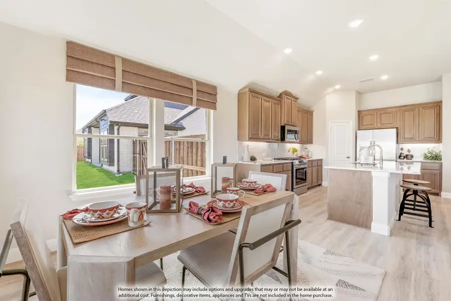 Open dining area with set table flowing into kitchen with wood cabinets, island, and stainless appliances