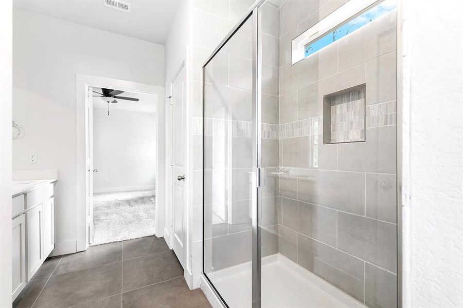 Another view of the primary bathroom displaying the beautiful tile selection for the shower.