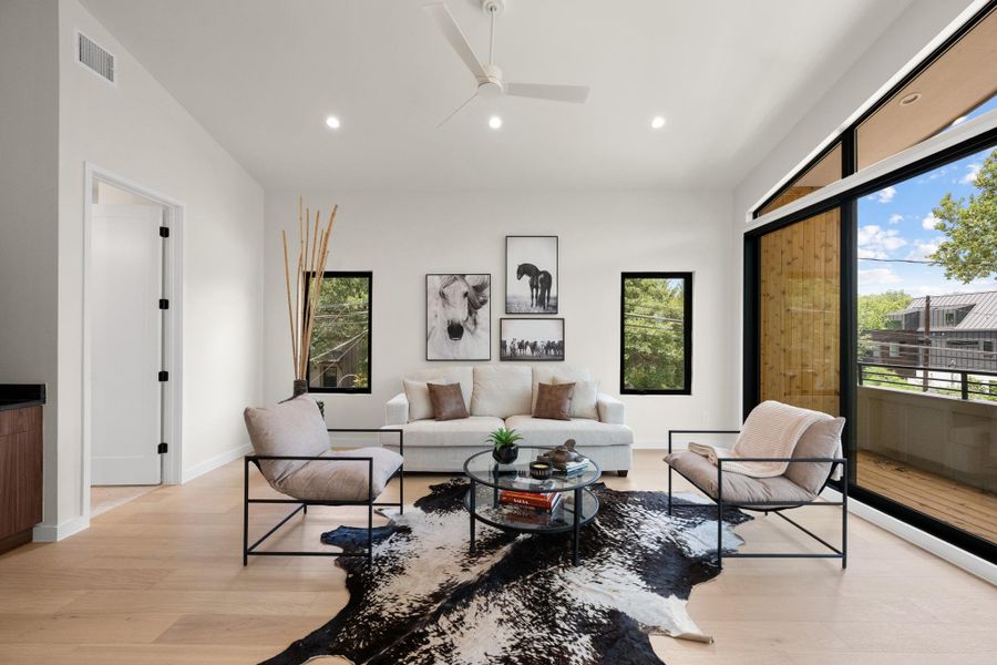 Bright interior features light hardwood floors and a modern ceiling fan, creating an inviting atmosphere. Bright interior features light hardwood floors and a modern ceiling fan, creating an inviting atmosphere.