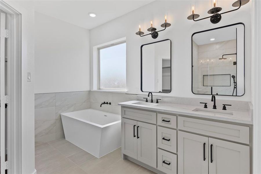 Full bathroom with a sink, a soaking tub, double vanity, and a shower stall