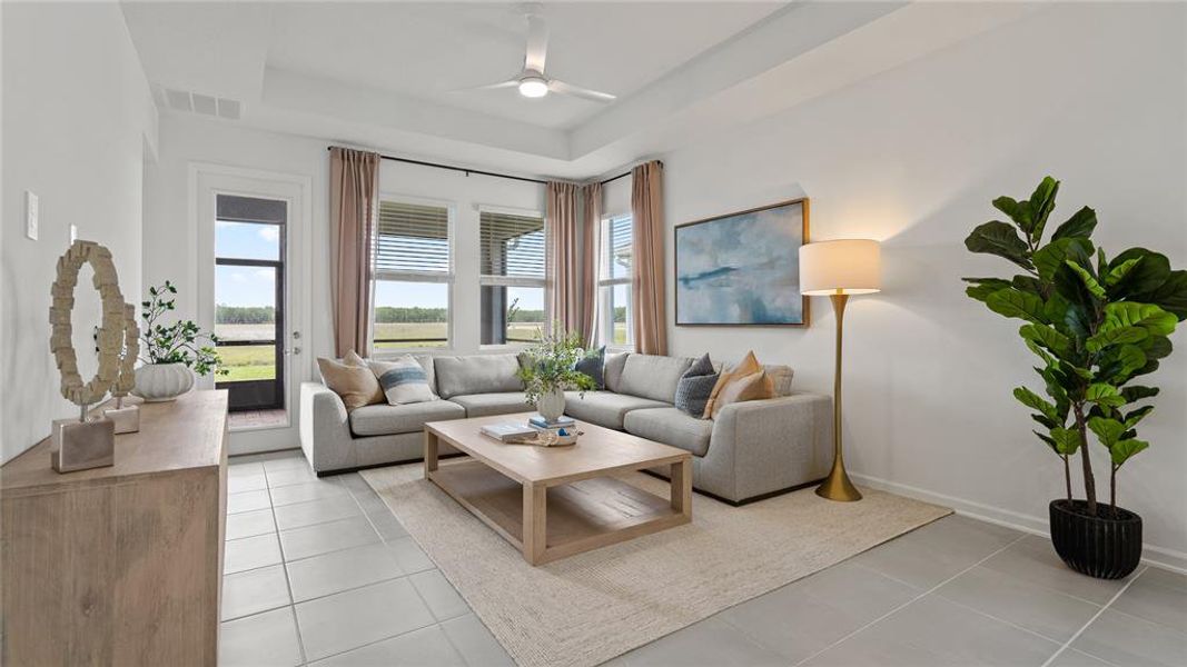 Living area featuring healthy amount of natural light, light tile patterned floors, and ceiling fan Living area featuring healthy amount of natural light, light tile patterned floors, and ceiling fan