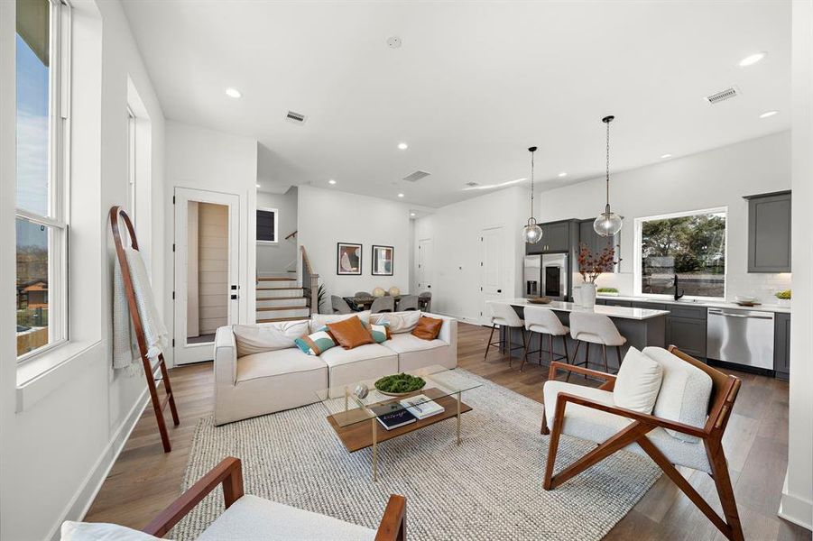 Spacious and inviting living area with abundant natural light, seamlessly connecting to a modern kitchen—ideal for relaxation and entertaining.