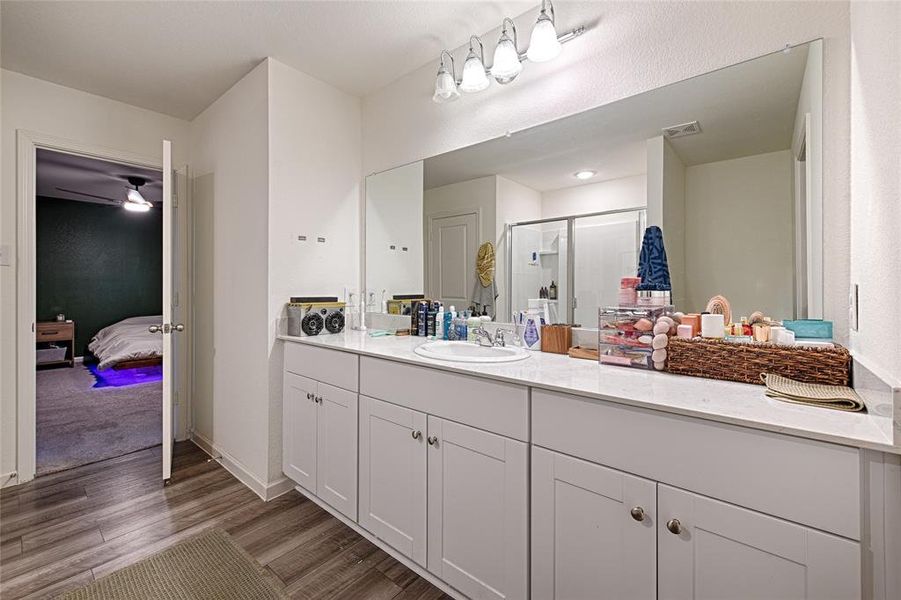 Ensuite bathroom with vanity, a shower stall, light wood-style floors, and ceiling fan Ensuite bathroom with vanity, a shower stall, light wood-style floors, and ceiling fan