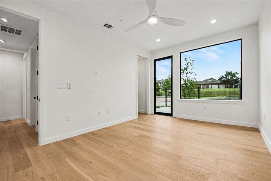 Bedroom with a door that leads outside to a patio and fenced yard.