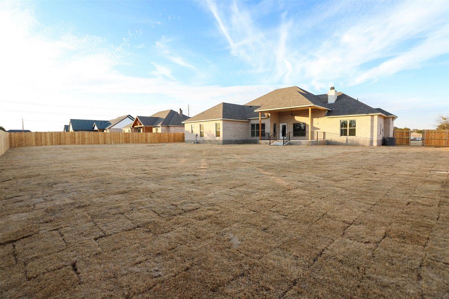 Back of property featuring a fenced backyard, a patio, and a chimney