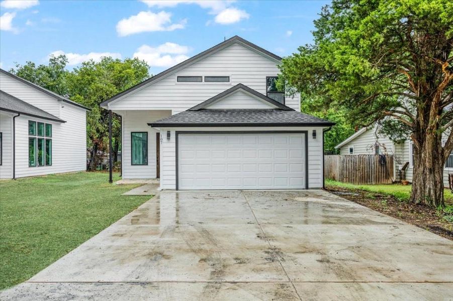 View of front of property with a garage and a front yard