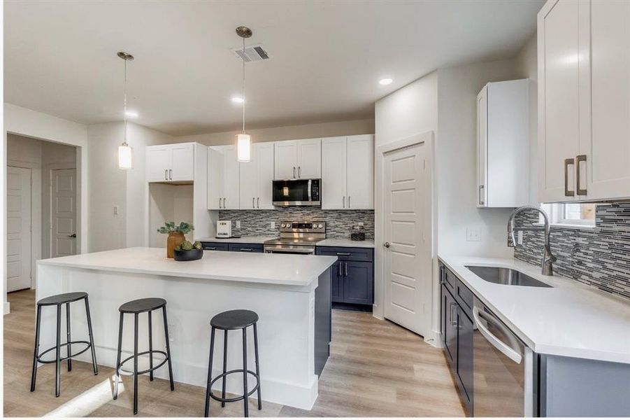 Kitchen featuring white cabinetry, stainless steel appliances, and light wood-type flooring