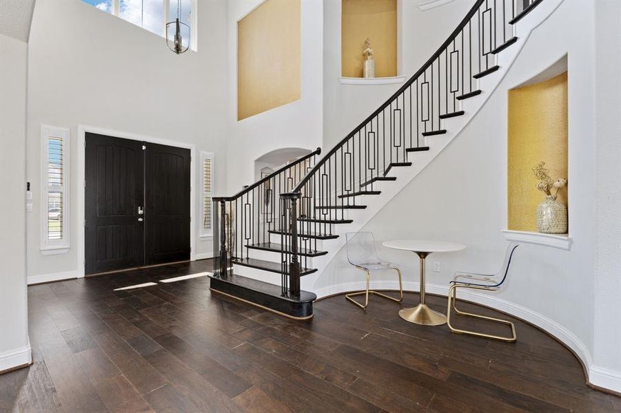 Entrance foyer with wood-type flooring and a towering ceiling