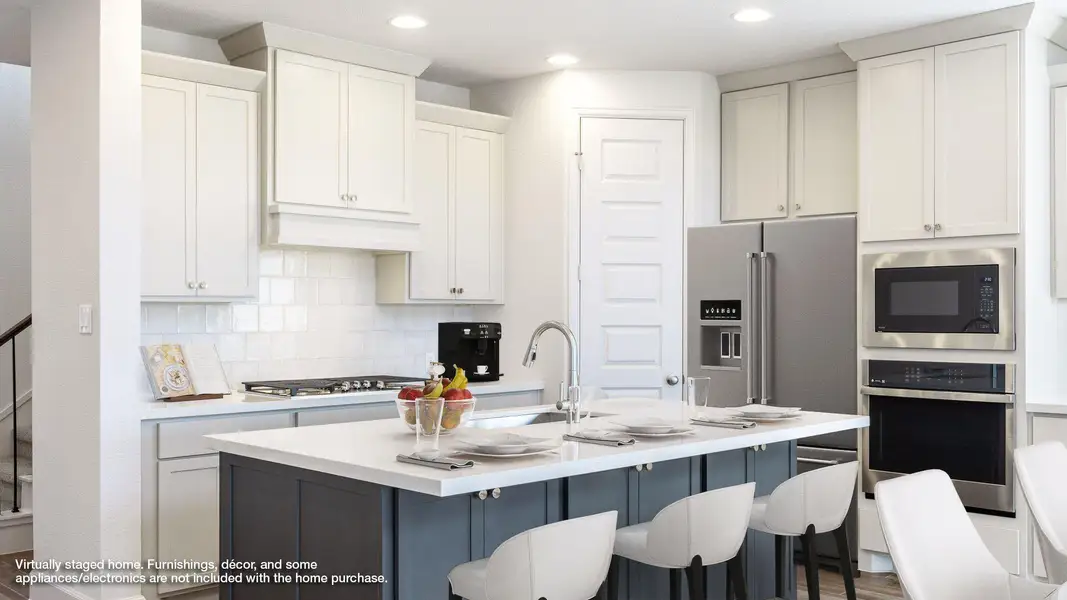 Kitchen with tasteful backsplash, stainless steel oven, a kitchen bar, built in microwave, and white cabinets Kitchen with tasteful backsplash, stainless steel oven, a kitchen bar, built in microwave, and white cabinets