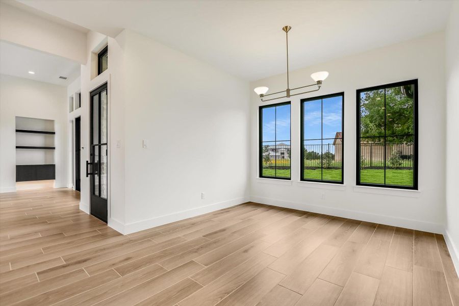 Light wood-finish tile flooring throughout, featuring a contemporary linear chandelier