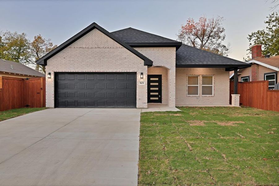 View of front of house with a lawn and a garage