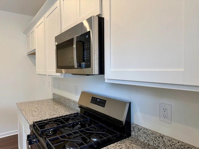 Kitchen - Chic white finishes and smooth surfaces shine.