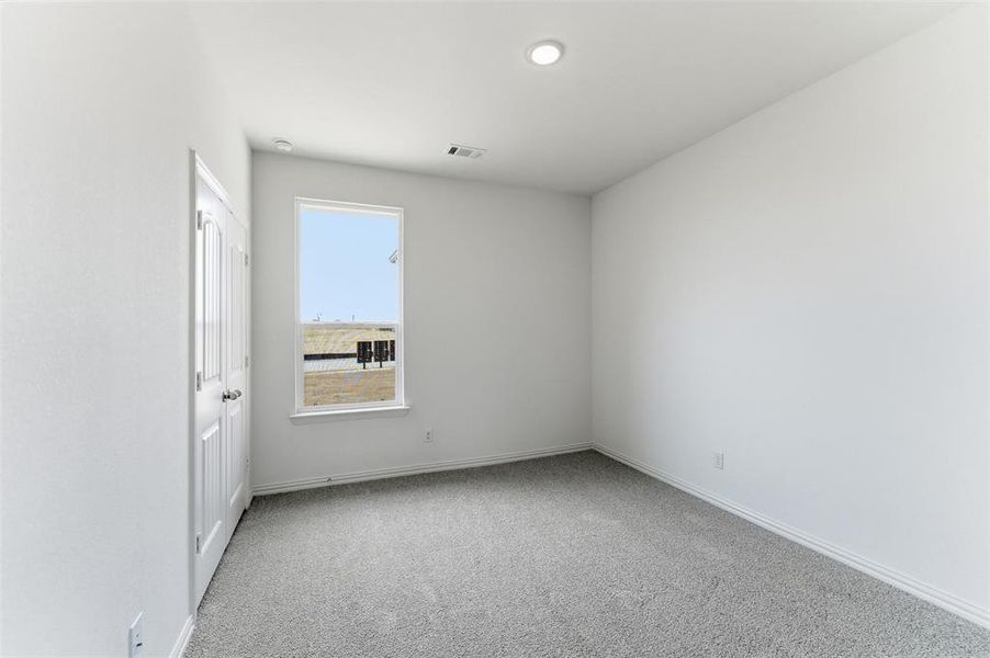 Spare room featuring light carpet and baseboards
