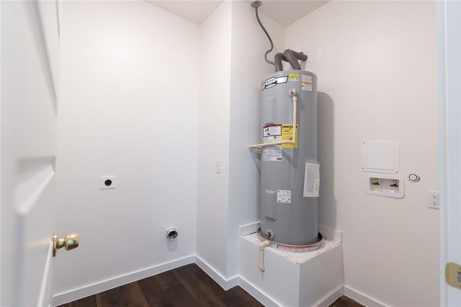 Washroom featuring hookup for an electric dryer, electric water heater, washer hookup, laundry area, and dark wood finished floors Washroom featuring hookup for an electric dryer, electric water heater, washer hookup, laundry area, and dark wood finished floors