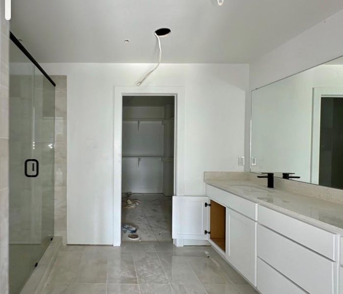 Full bath with vanity, a stall shower, and a spacious closet Full bath with vanity, a stall shower, and a spacious closet