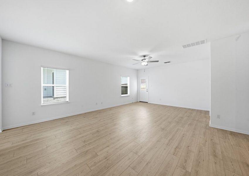 Family room featuring a ceiling fan, a window with natural light, and wood-look vinyl flooring. Family room featuring a ceiling fan, a window with natural light, and wood-look vinyl flooring.