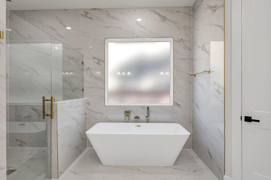 The owner’s retreat en-suite bathroom with large soaking tub, and spacious walk-in shower with rain shower head.